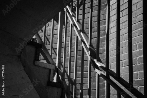 Escaleras con barrotes y pared de ladrillos. photo