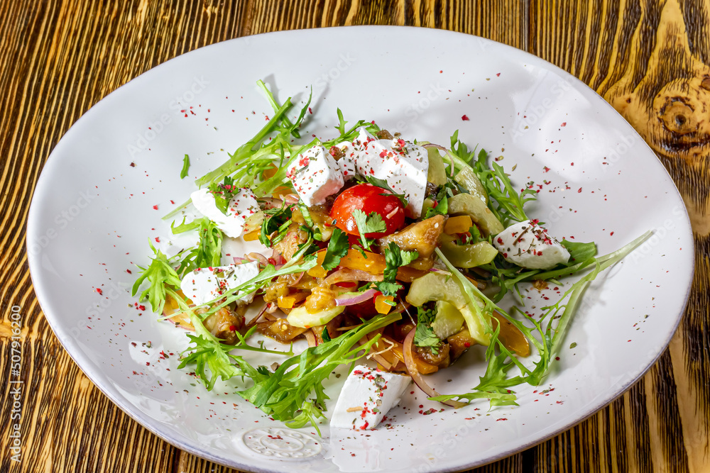 Variety of grilled vegetables salad red bell pepper, zucchini, eggplant with spinach leaves and feta cheese. Food recipe background. Variety of grilled vegetables salad red bell pepper, zucchini, eggplant with spinach leaves and feta cheese. Food recipe background.