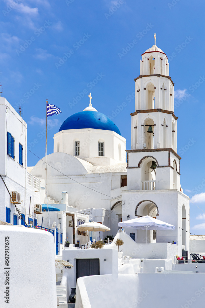 White church with a blue dome on Santorini island in Greece. Hot summer sun day. White church with a blue dome on Santorini island in Greece. Hot summer sun day.
