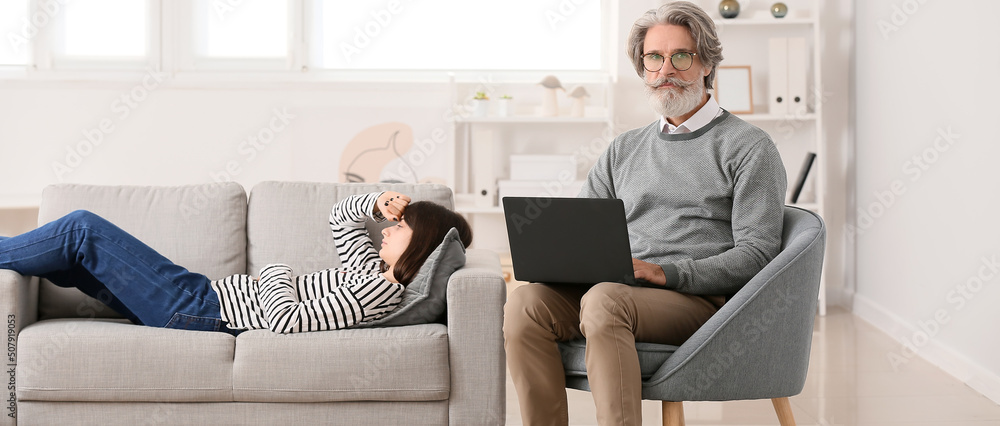 Male psychologist working with young girl in office