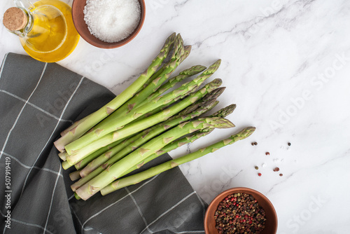 Green fresh asparagus with spices a on a white background