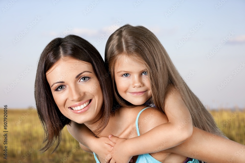 Little child daughter hugging mother while standing in the middle of the field. Little child daughter hugging mother while standing in the middle of the field.