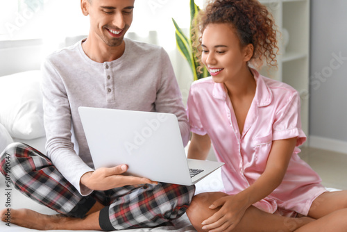 Young couple using laptop i...