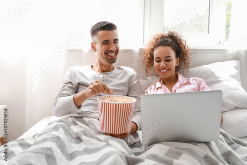 Young couple with popcorn w...
