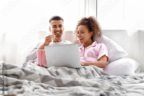 Young couple with popcorn w...