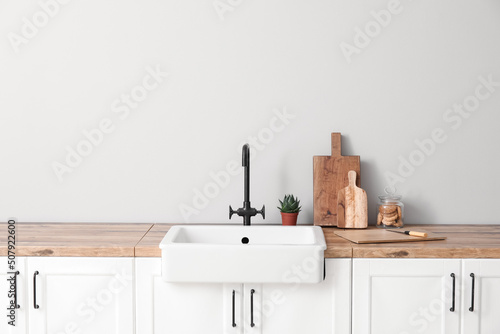Fotobehang Cutting boards with jar of cookies, sink and houseplant on counters near light w