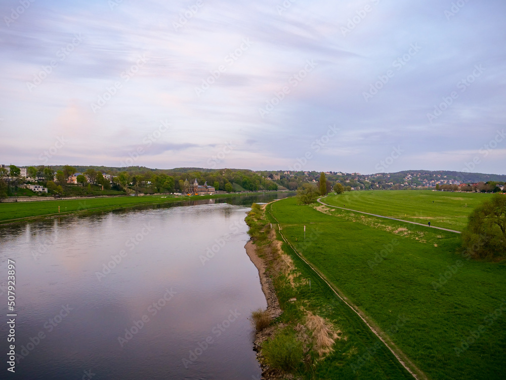 Large riverbanks of the Elbe river in Dresden. Green meadows in the Elbe valley. There is a lot of space for the river and the water before being dangerous for the buildings next to it.