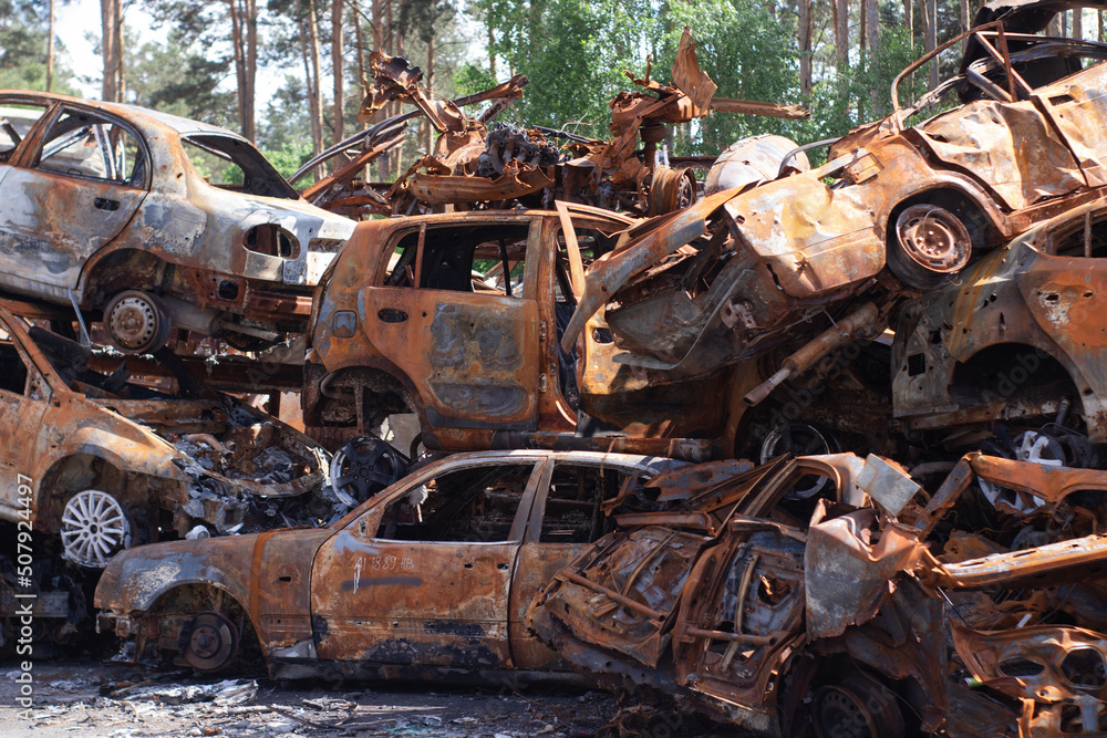 Fototapeta premium war in ukraine. Car graveyard. Shot cars of civilians. russia's war against Ukraine. Burnt and blown up car. Cars damaged after shelling. irpin bucha. war crimes