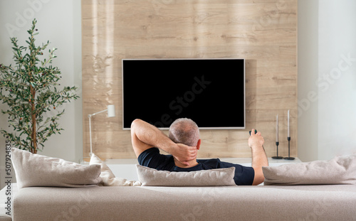 man sitting on sofa in modern living room back view