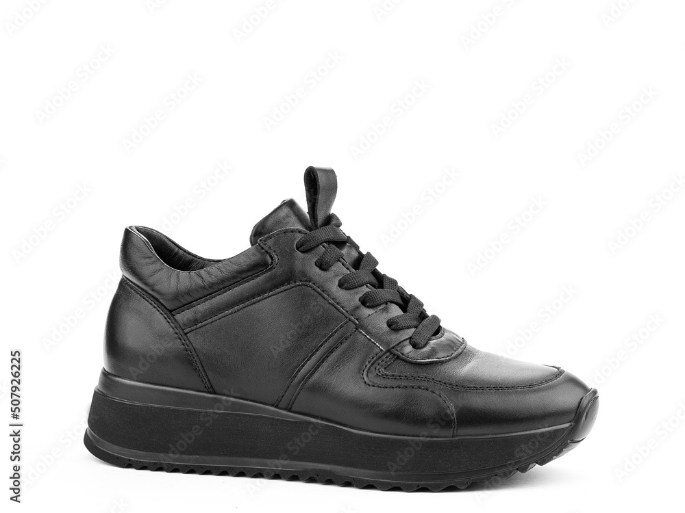 Black leather classic sneakers with laces. Casual men's style. Black rubber soles. Isolated close-up on white background. Right side view.