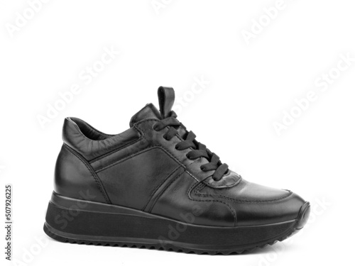 Obraz na płótnie Black leather classic sneakers with laces. Casual men's style. Black rubber soles. Isolated close-up on white background. Right side view. w salonie