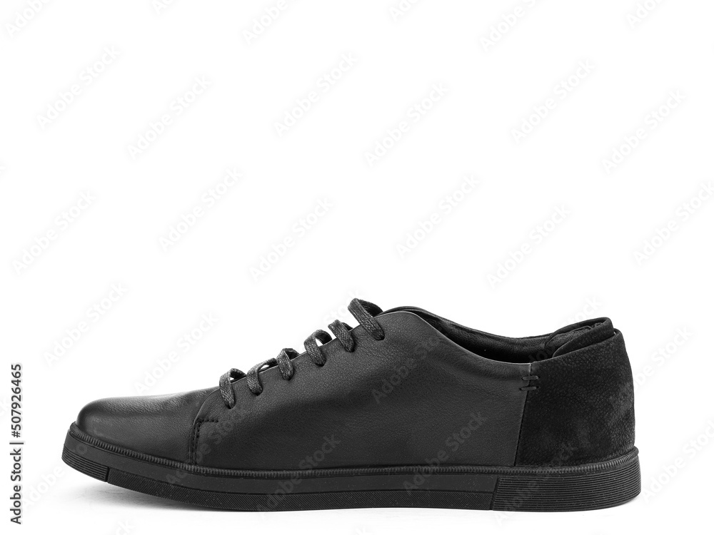 Black leather classic sneakers with laces. Casual men's style. Black rubber soles. Isolated close-up on white background. Left side view.