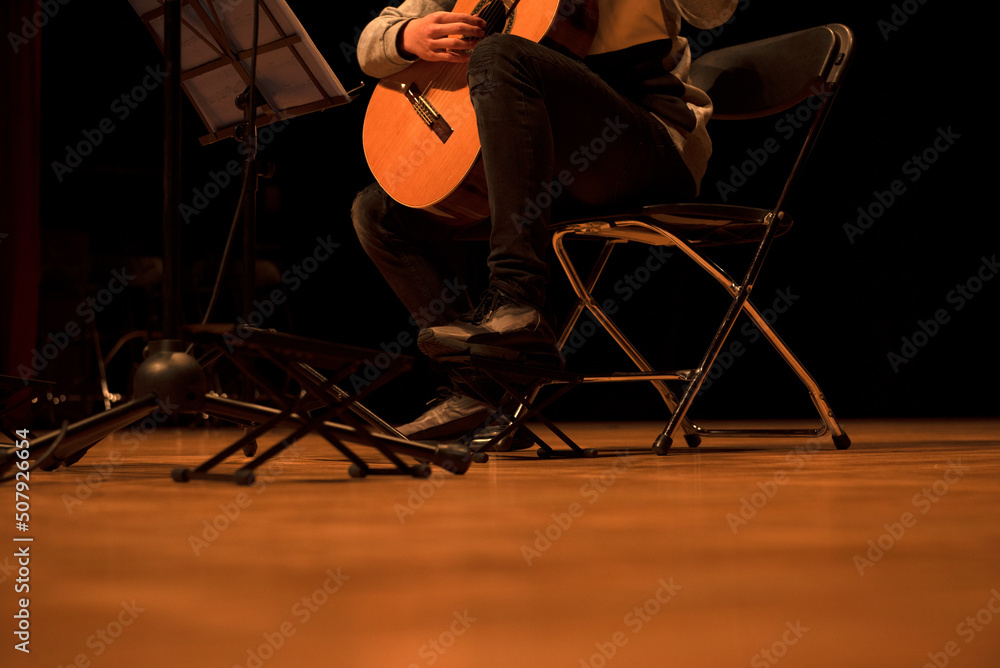 child play guitar on stage in private lessons.