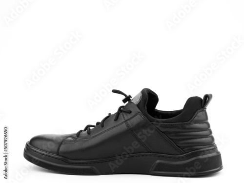 Black leather classic sneakers with laces. Casual men's style. Black rubber soles. Isolated close-up on white background. Left side view. © MONIUK ANDRII