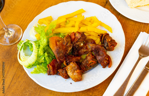Toston cuchifrito, fried marinated suckling pig served with lettuce salad. Popular meat dish from Extremadura, Spain