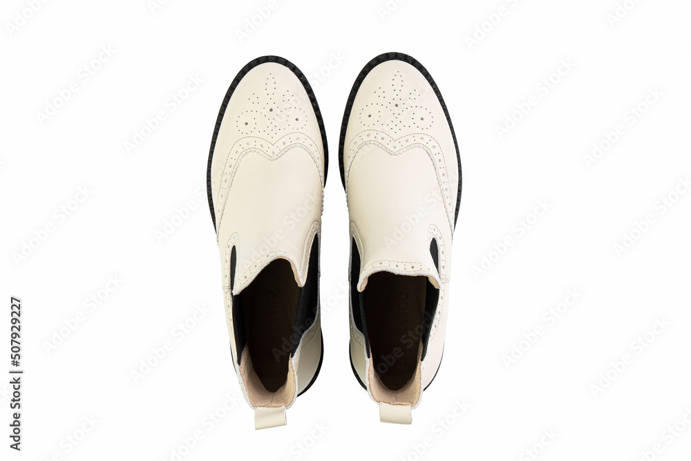 White leather chelsea boots. Isolated close-up on white background. Top view. Fashion shoes.
