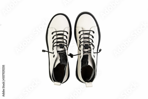 Obraz na płótnie White leather ankle boots with black laces. Isolated close-up on white background. Top view. Casual seasonal shoes. Fashion shoes w salonie