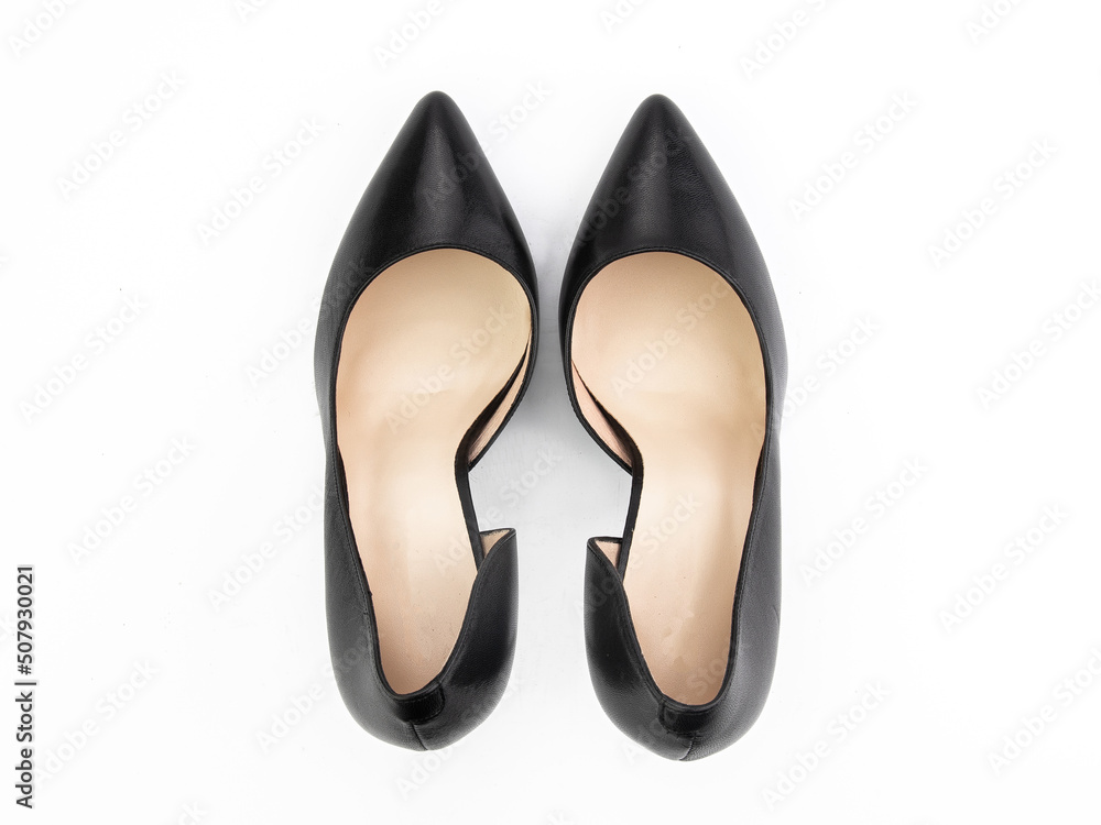 Classic and elegant high-heeled women shoes. Stylish black shoes on high thin heels and with a pointed toe. Isolated object close up on white background. Top view.