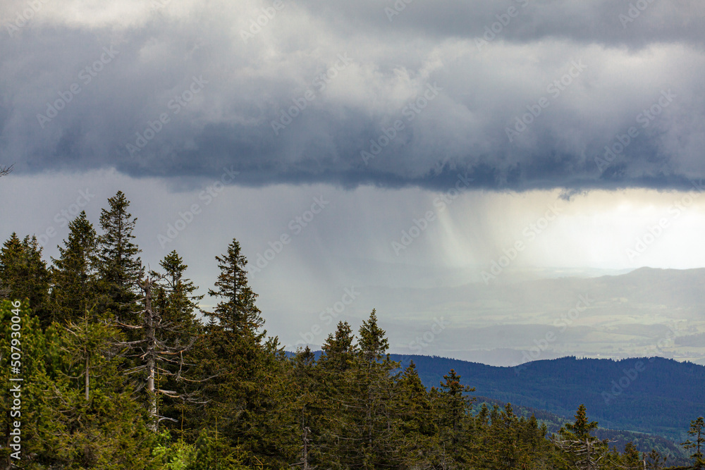 Storm cloud rain fall over mountain forest hills.