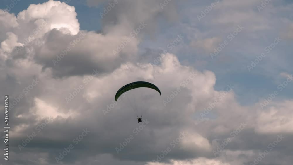 paragliding in tandem over flat fields in cloudy weather paragliding in tandem over flat fields in cloudy weather