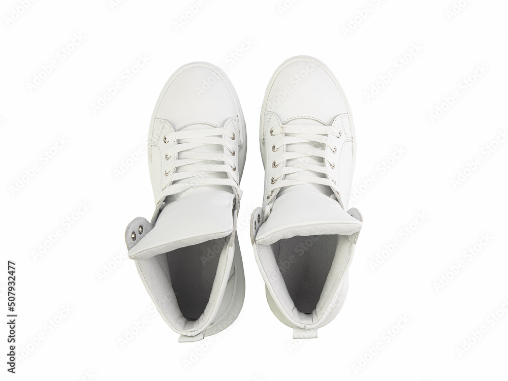 White leather sneakers. Casual women's style. White lacing and white rubber soles. Isolated close-up on white background. Top view. Fashion shoes