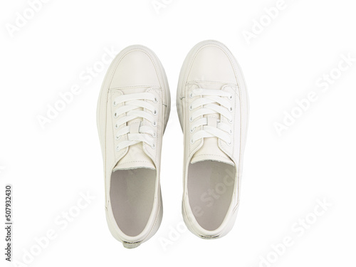 Obraz na płótnie White leather sneakers. Casual women's style. White lacing and white rubber soles. Isolated close-up on white background. Top view. Fashion shoes w salonie