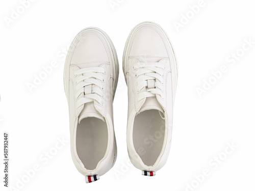 Obraz na płótnie White leather sneakers. Casual women's style. White lacing and white rubber soles. Isolated close-up on white background. Top view. Fashion shoes w salonie