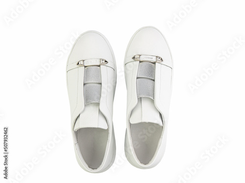 Obraz na płótnie White leather sneakers. Casual women's style. White lacing and white rubber soles. Isolated close-up on white background. Top view. Fashion shoes w salonie