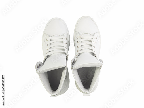 Obraz na płótnie White leather sneakers. Casual women's style. White lacing and white rubber soles. Isolated close-up on white background. Top view. Fashion shoes w salonie