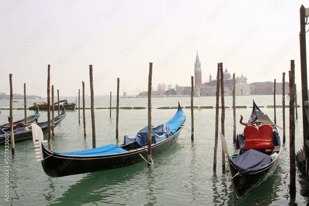 Clásicas góndolas negras ancladas en lago de Venecia con Basílica de fondo