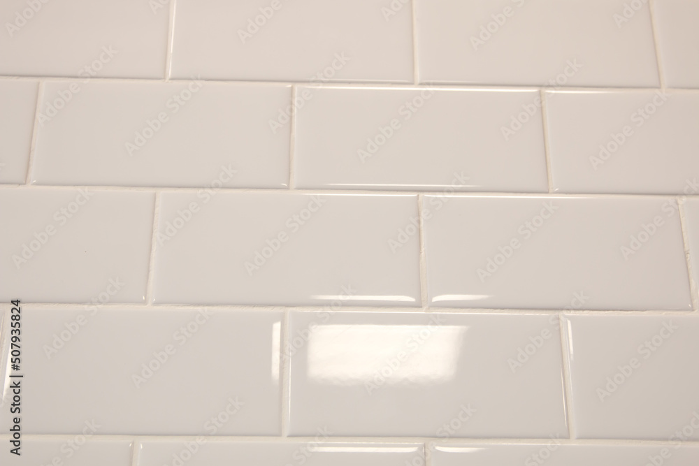 White tiles in the shape of bricks on the wall White tiles in the shape of bricks on the wall