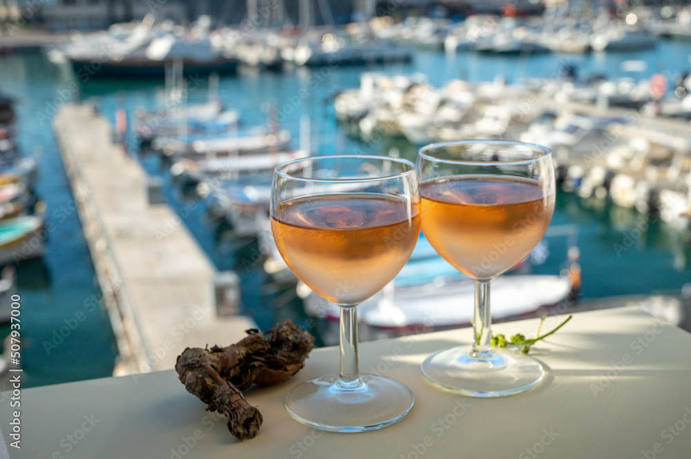 Cold rose wine in glasses served on outdoor terrace in sunlights with view on old fisherman's harbour with colourful boats in Cassis, Provence, France Cold rose wine in glasses served on outdoor terrace in sunlights with view on old fisherman's harbour with colourful boats in Cassis, Provence, France