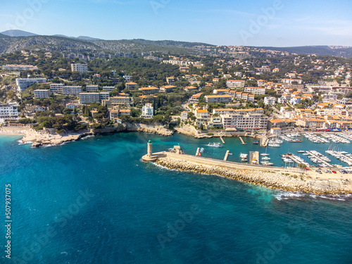 Fototapeta Naklejka Na Ścianę i Meble -  Panoramic aerial view on cliffs, blue sea, beach, houses, streets and old fisherman's harbour with lighthouse in Cassis, Provence, France