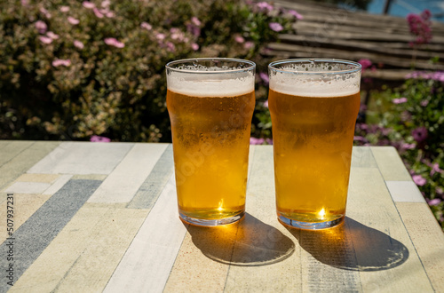 Two glasses of fresh cold lager beer served outdoor in snack bar with view on Calanque de Figuerolles in La Ciotat, Provence, France