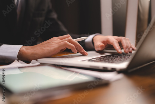 professional business person are working in communication of online marketing job plan with laptop by using a hand to typing computer keyboard at modern office workplace or co-working space