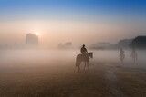 Three mounted polices walking thier horses at Kolkata maidan, in a foggy winter morning.