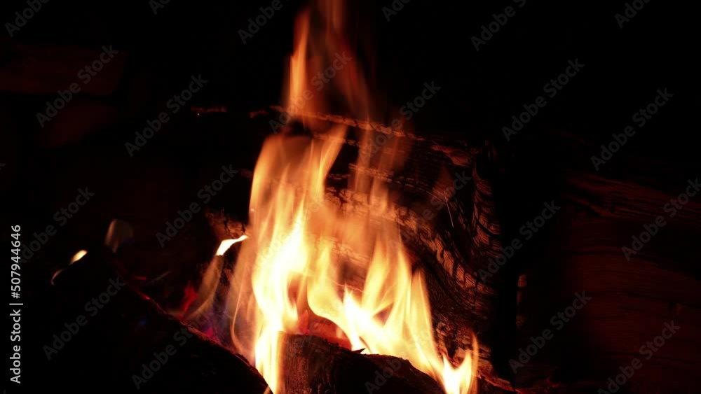 Orange flames of a campfire close-up. Tongues of flame move over the firewood. Horizontal video of nature. High quality 4k footage Orange flames of a campfire close-up. Tongues of flame move over the firewood. Horizontal video of nature. High quality 4k footage