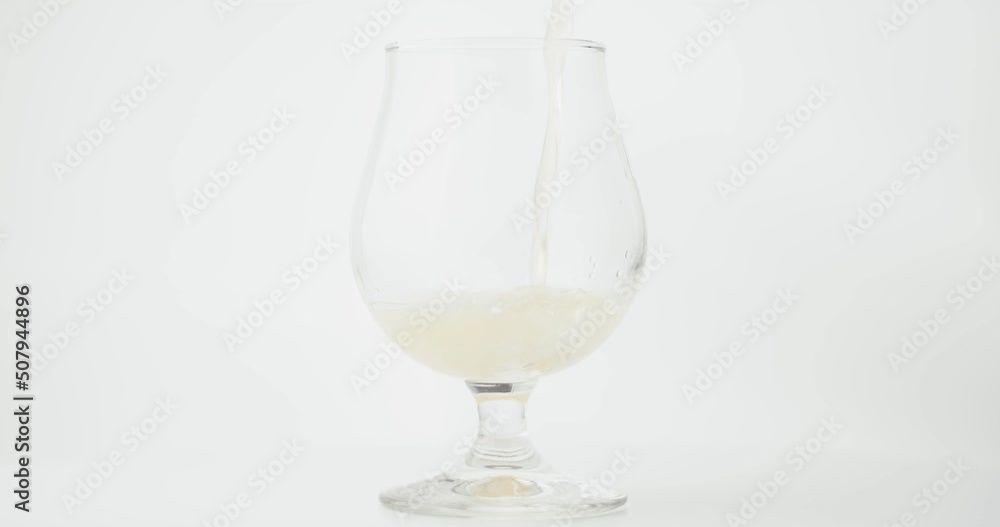 Beer poured in full glass foam collar in slow motion close up Beer poured in full glass foam collar in slow motion close up