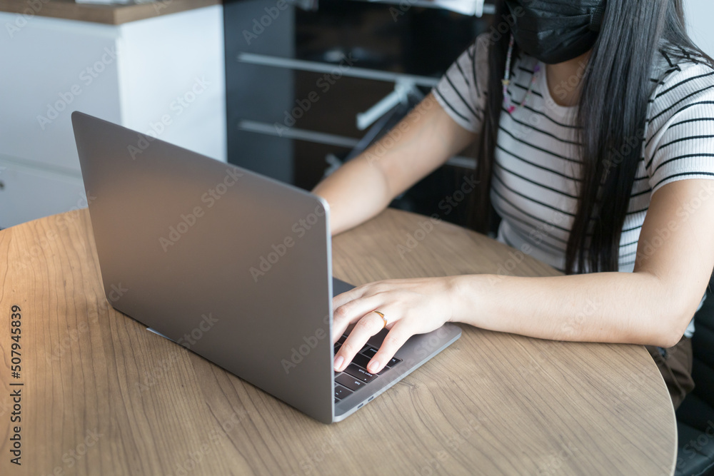 Working from home on laptop while typing chat to customer communicates on internet in home office Working from home on laptop while typing chat to customer communicates on internet in home office
