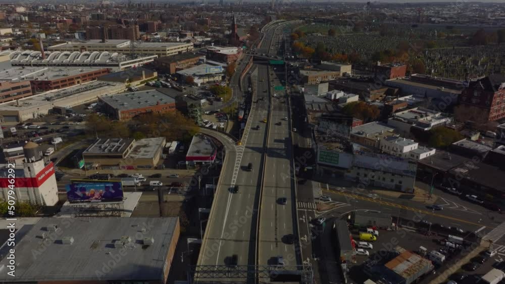 Forwards fly above multilane trunk road in town. Tilt up revel of buildings in suburbs of large city. Queens, New York City, USA Forwards fly above multilane trunk road in town. Tilt up revel of buildings in suburbs of large city. Queens, New York City, USA