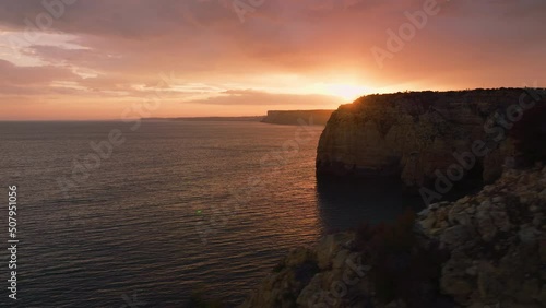 beautiful sunset on cliffs aerial view sun rays through clouds portugal lagos 