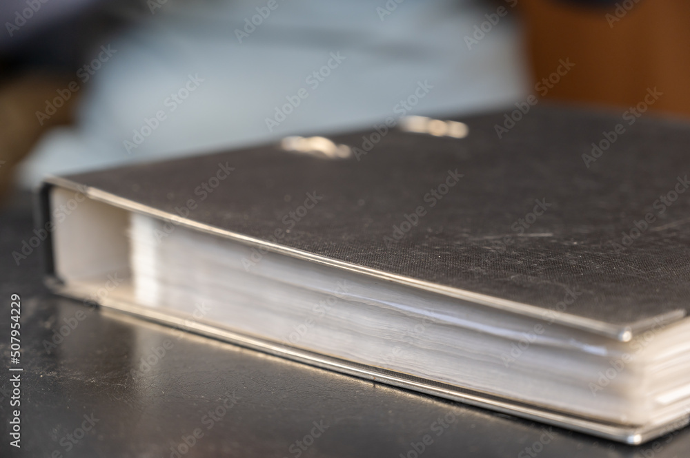 Gray file folder with binder. Papers are on a black desk. Close-up. Selective focus Gray file folder with binder. Papers are on a black desk. Close-up. Selective focus