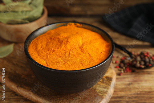 Aromatic saffron powder in bowl on wooden table