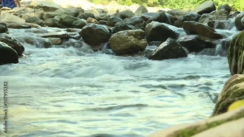 Water in a rocky mountain river flows through the stones in a rapid stream