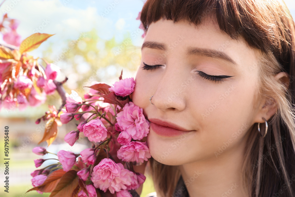 Beautiful young woman near blossoming sakura tree in park, closeup Beautiful young woman near blossoming sakura tree in park, closeup