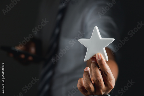 Satisfaction concept mobile. Businessman holding a white star showing satisfaction while working 