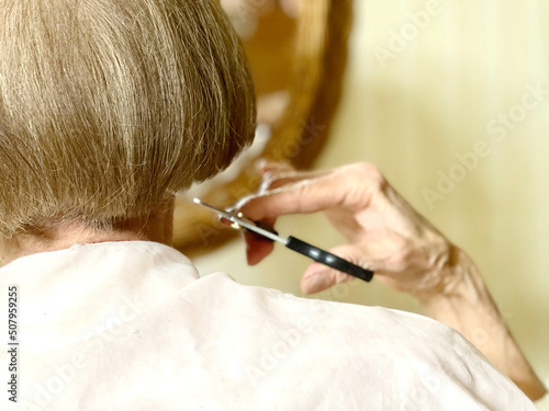 自分で髪を切る高齢女性の後ろ姿