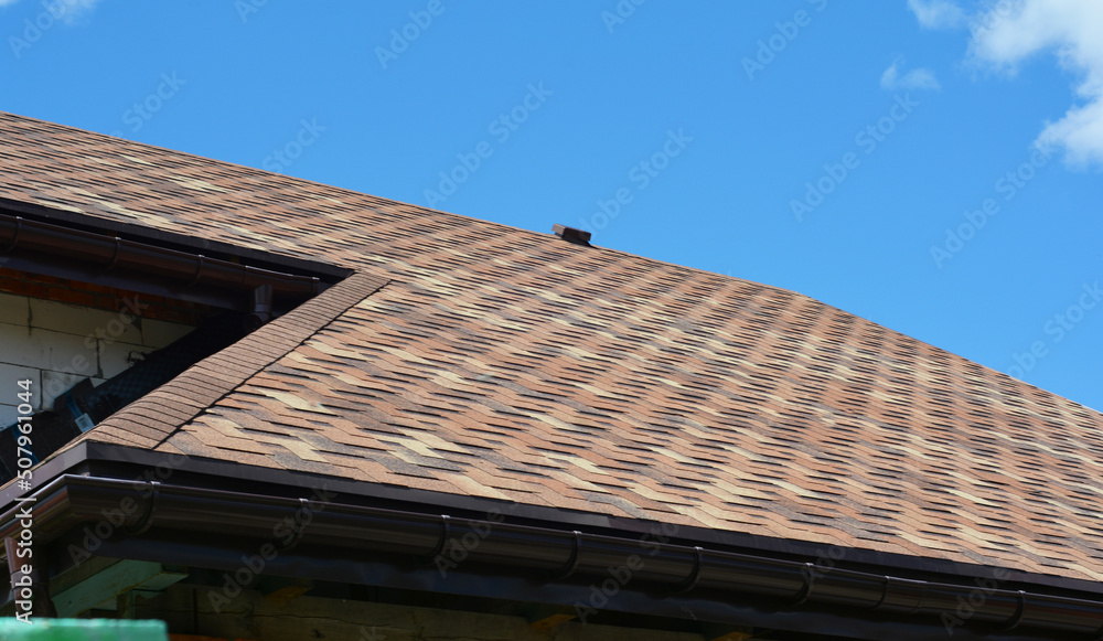Close up on asphalt shingles roofing construction. House asphalt shingles roofing construction waterproofing with vent on rooftop.