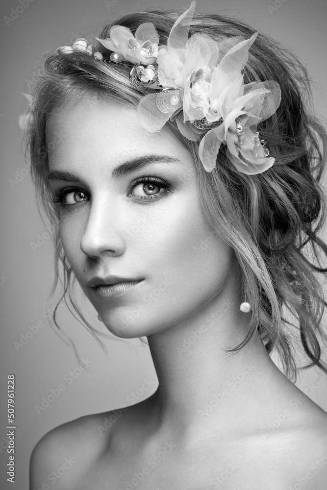 Young blonde woman with tiara on her head. Black and white photo. Beautiful model woman with curly hairstyle. Care and beauty hair products. Perfect make-up