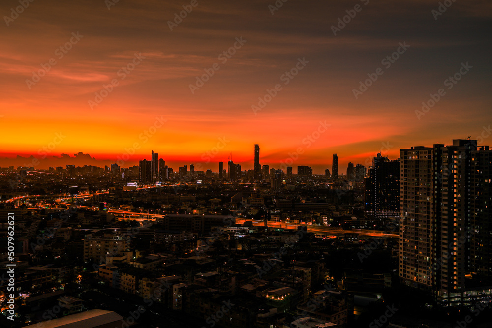 The high angle background of the city view with the secret light of the evening, blurring of night lights, showing the distribution of condominiums, dense homes in the capital community The high angle background of the city view with the secret light of the evening, blurring of night lights, showing the distribution of condominiums, dense homes in the capital community